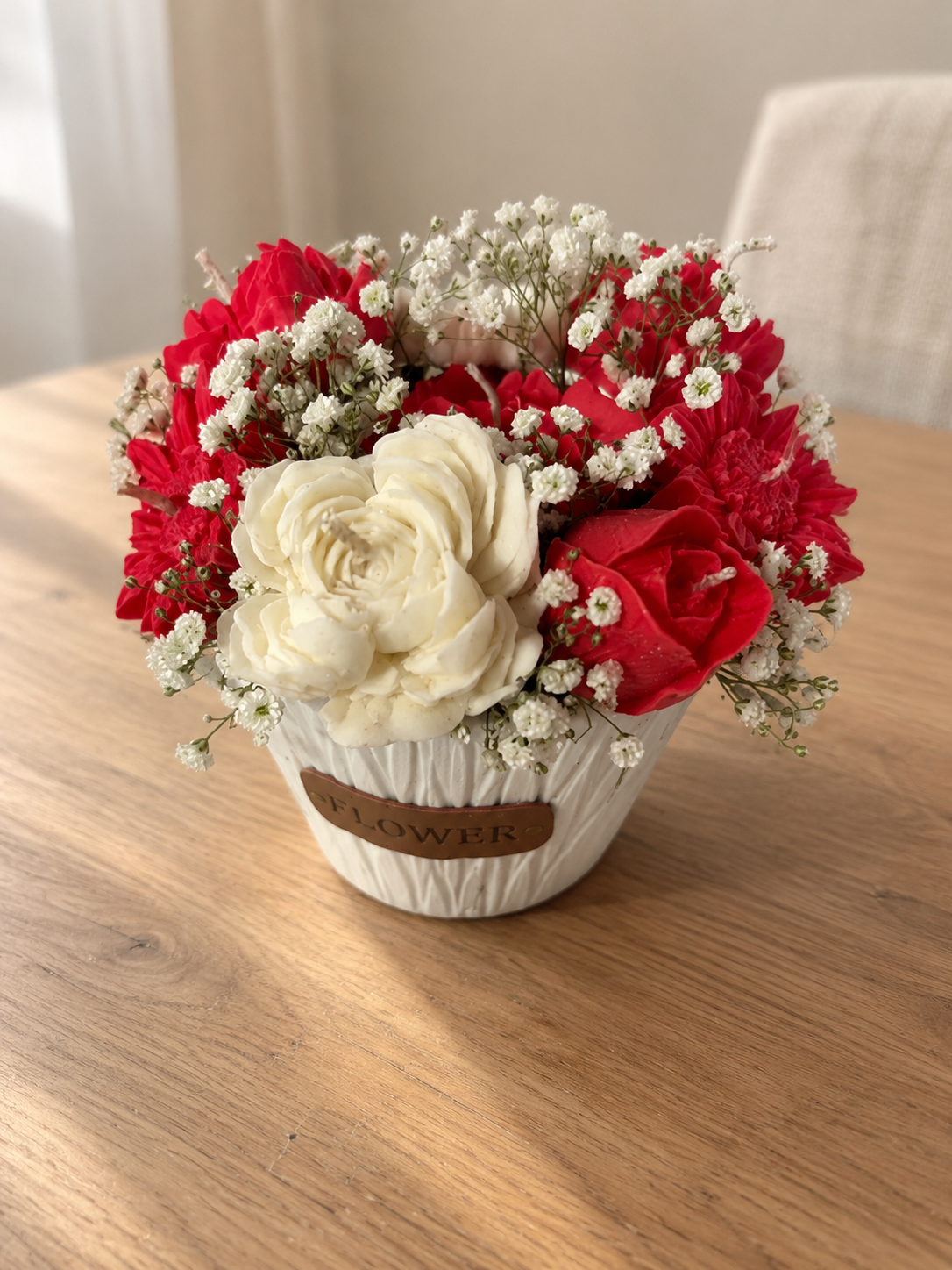 White textured Flower pot filled with red and cream sculpted wax flower candles and white baby's breath