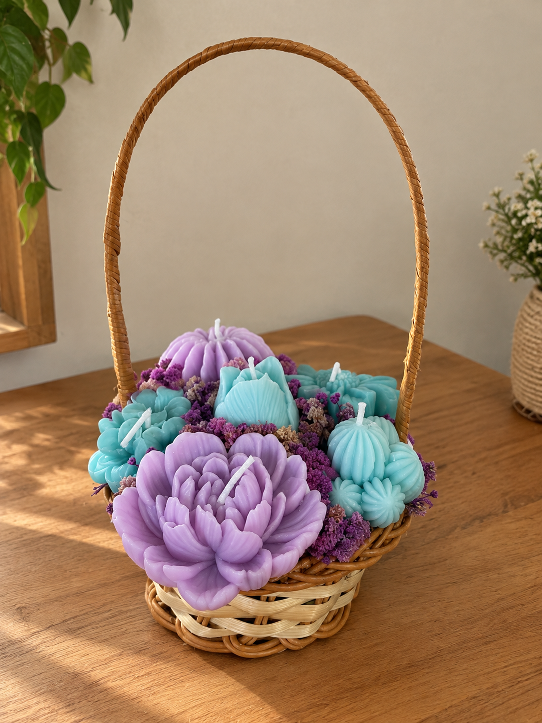 Wicker basket of lilac peony and aqua flower and cactus candles with purple dried flowers